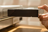 Hand putting VHS tape in a VCR
