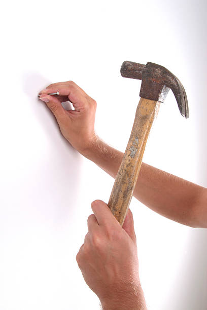 Man Hammering Nail Into Wall Stock Photos, Pictures & Royalty-Free Images -  iStock