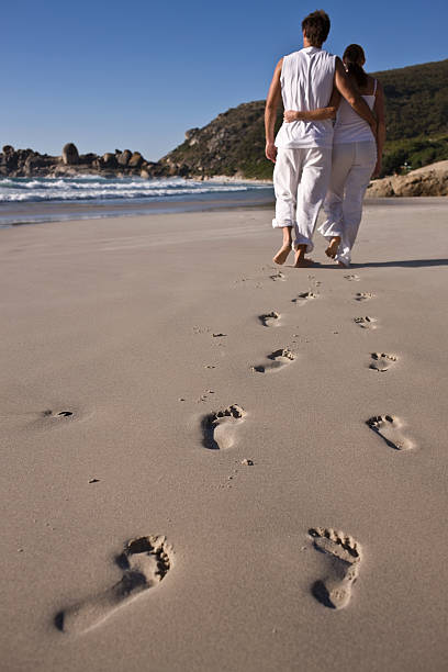 istock Young couple walking together on beach 173555334