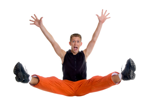 Full length portrait of a confident young sportsman shirtless jumping isolated over white background.