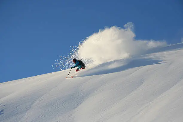 Young male skiing in deep powder snow in Stranda, Norway