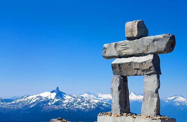 Whistler mountain sculpture in inukshuk  Whistler mountian Insuksuk with Blacktusk Mountain in the background. inukshuk whistler cairn mountain stock pictures, royalty-free photos & images