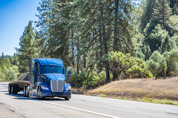 istock Bonnet powerful big rig semi truck tractor transporting fastened cargo on flat bed semi trailer driving on the multiline highway road 1735595198