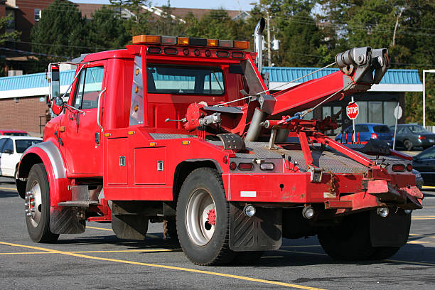 Red Tow Truck Red tow truck in a mall parking lot. tow truck stock pictures, royalty-free photos & images