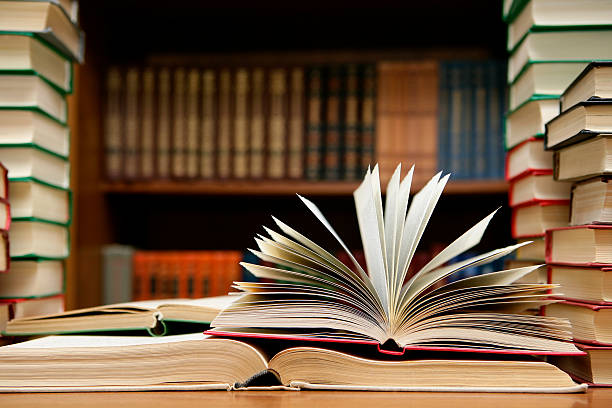 Book open with pages flipping open Close-up of books at the library. Shallow depth of field. book display stock pictures, royalty-free photos & images