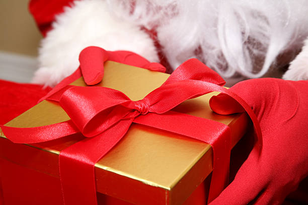 istock Santa Holding A Gold Gift Box With Red Ribbon 173562468