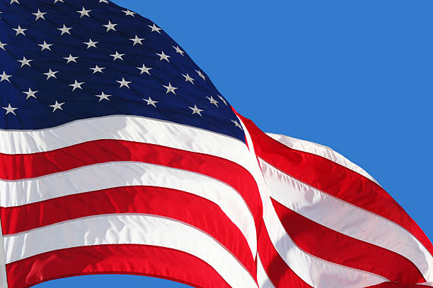 istock An American flag waving in the wind against blue background 173562822