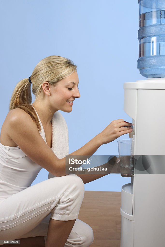 Getting a Drink Woman drinking water from a water cooler after a workout. 18-19 Years Stock Photo