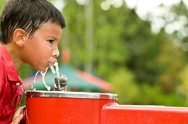 heat relief Little boy drinking from the fountain. drinking fountain stock pictures, royalty-free photos & images