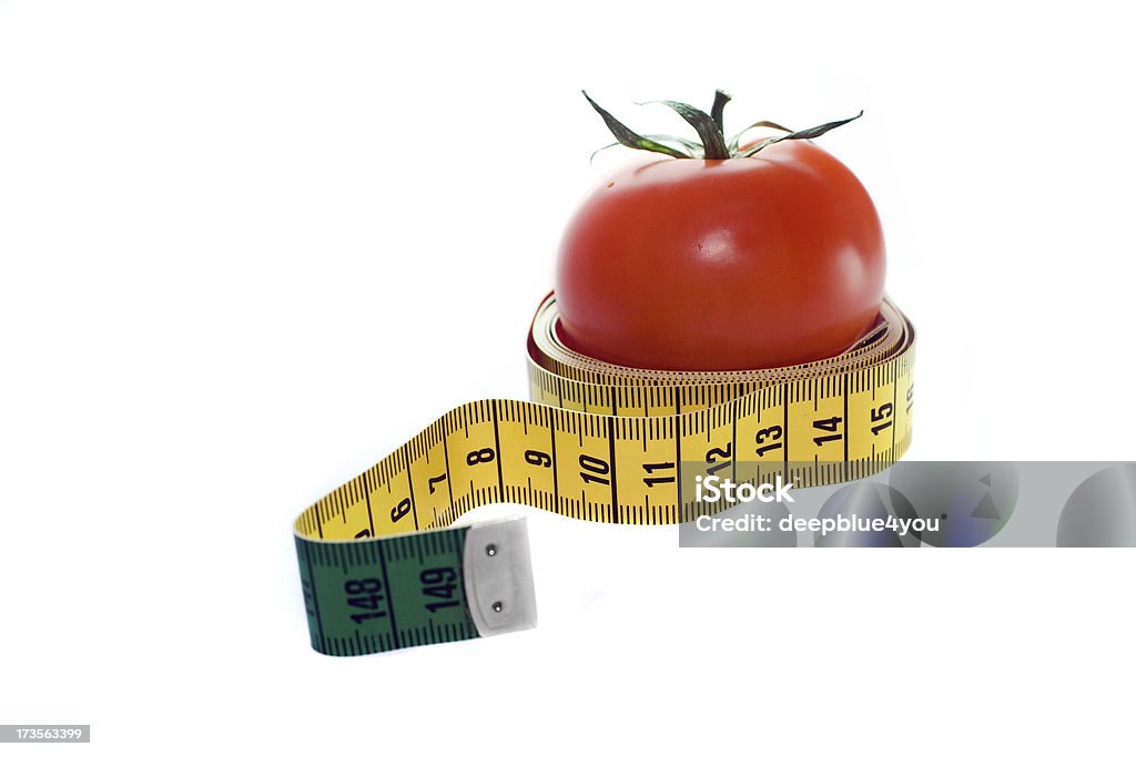 Tomatoe in a measuring tape "close shot of a tomatoe in a woundet up measuring tape, on white background" Antioxidant Stock Photo