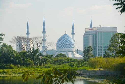 Shah Alam, Malaysia: October 15, 2023- Sultan Salahuddin Abdul Aziz Mosque, a majestic architectural wonder located in Shah Alam, Malaysia, graces the city's landscape beside a serene lake, embodying the perfect blend of spirituality, culture, and urban beauty