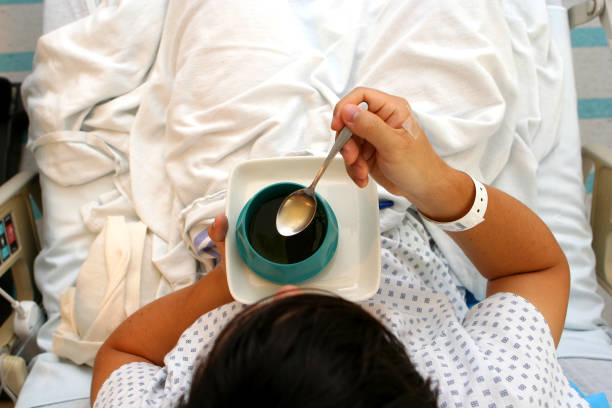 A hospital patient eating with a spoon stock photo
