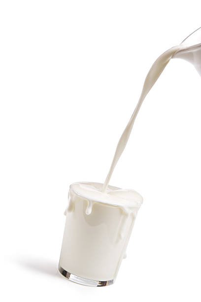 Overflowing glass of milk stock photo