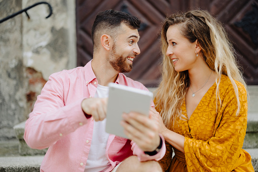 Young couple using digital tablet and having video call