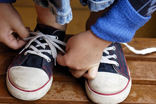 Tyieing the strings Child's hands tyeing sport shoes.More of this & other kids atBEING A KID LIGHTBOX child tied up stock pictures, royalty-free photos & images