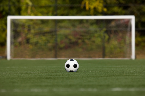 Soccer ball in front of goal at starting line.