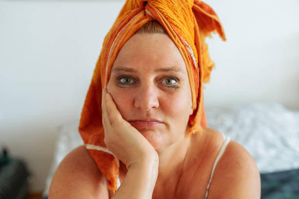 Middle aged woman with smudged mascara portrait middle-aged woman with towel on wet hair, after shower, with smeared, leaking natural mascara on face. long lasting makeup concept, benefits of cleansing skin from cosmetics, facial skin care woman mascara smudged stock pictures, royalty-free photos & images