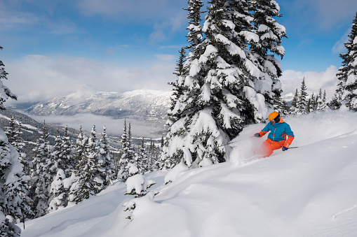 Male skiing fresh powder in the mountains. Top ski destinations in the world. Best ski resorts in North America. Skiing in Whistler, BC, Canada