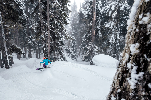 Female skiing fresh powder in the mountains. Winter ski vacation escaping in the mountains. Skiing at Whistler Mountain.