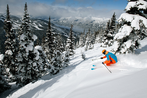 Male skiing fresh powder in the mountains. Top ski destinations in the world. Best ski resorts in North America. Skiing in Whistler, BC, Canada