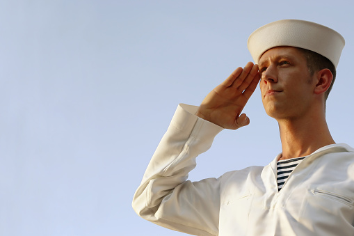serious young sailor saluting - shot in natural light