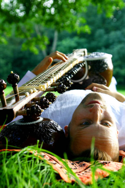 istock man on the grass with sitar 173569614