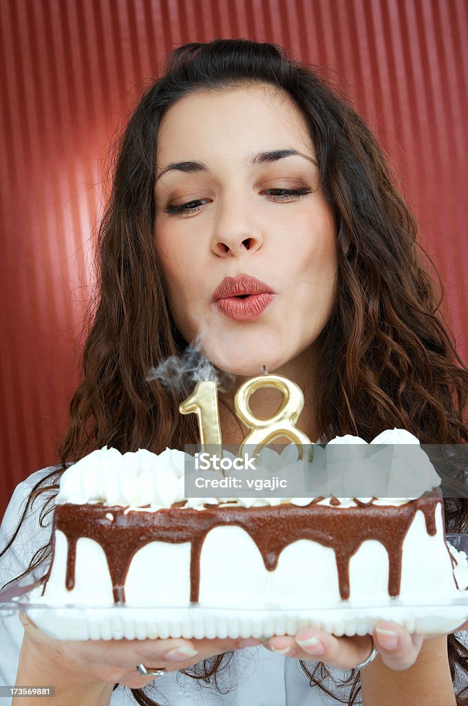 Teenage Girl Blowing Birthday Cake Candles Closeup of young beautiful girl Blowing Birthday Cake 18 number Candles 18-19 Years Stock Photo