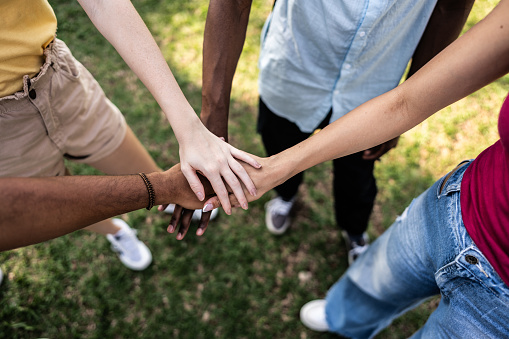 Close-up of friends stacking hands outdoors