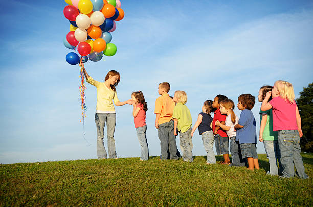 niños esperando en línea de globos - child waiting in line in a row party fotografías e imágenes de stock