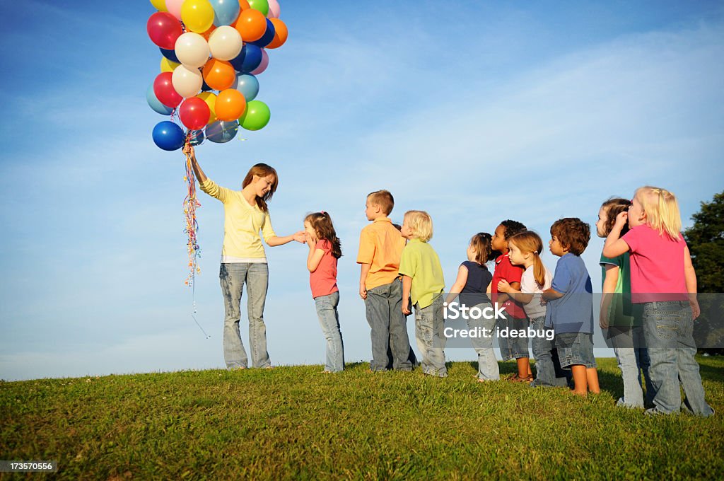 Enfants la queue pour ballons - Photo de Faire la queue libre de droits