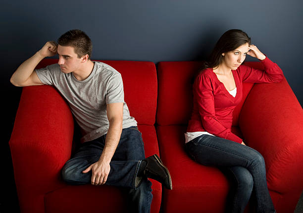 istock A couple in a little disagreement sitting on red couch 173571424