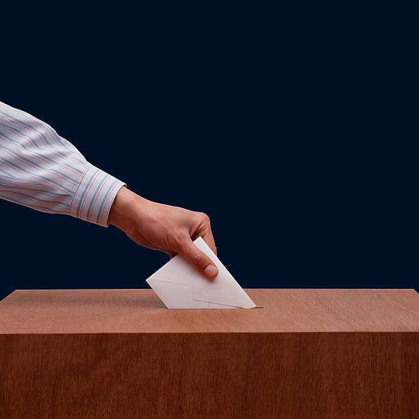 istock Hand placing ballot paper into wooden box 173571492
