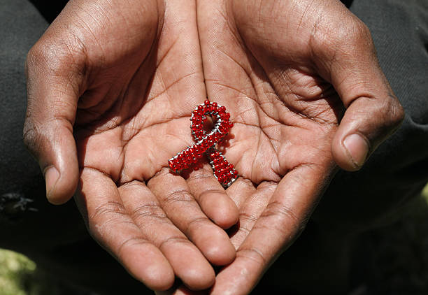 Beaded AIDS in hands A hand made beaded AIDS symbol in the hands of a black man. hiv stock pictures, royalty-free photos & images