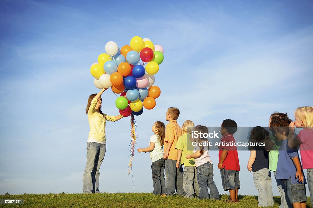 Bambini in attesa in linea per i palloncini - Foto stock royalty-free di Fare la fila