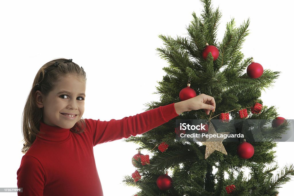 Girl in Christmas A young girl decorating a Christmas tree. 10-11 Years Stock Photo