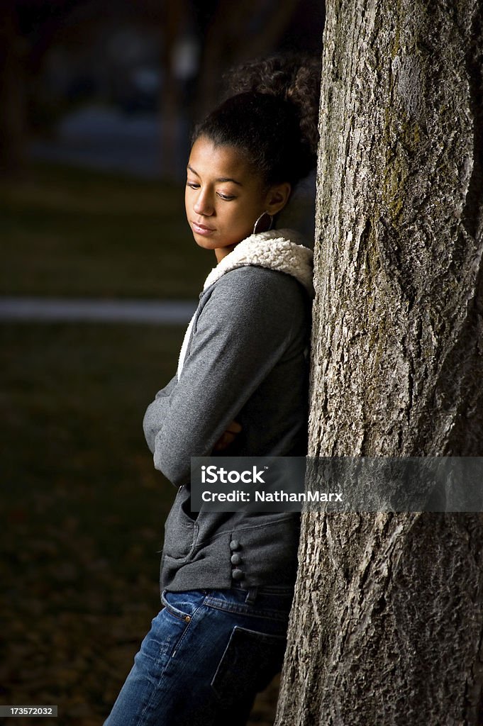 Triste adolescente s'appuyant sur un arbre - Photo de Adolescent libre de droits