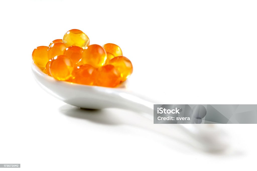 Salmon caviar on spoon Ikura over white spoon. Macro shot on white background. Selective focus. Cut Out Stock Photo