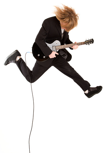 guitar hero jumping in the air with a business suit