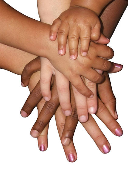 Multiple hands on top of each other on white surface stock photo
