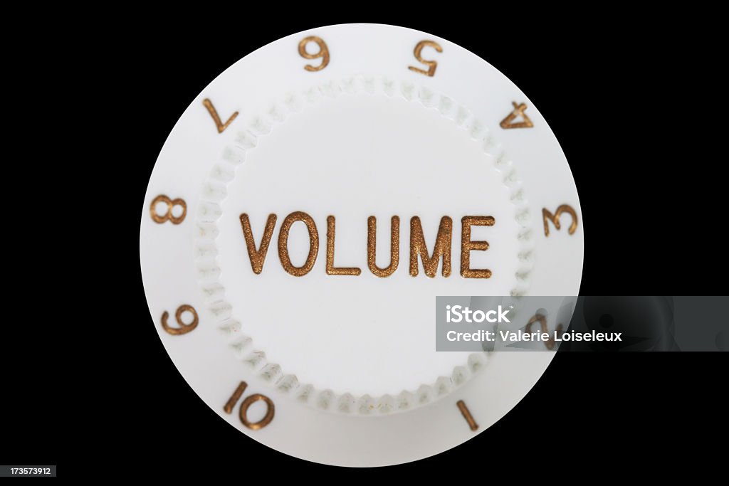 Volume Knob Electric guitar volume knob in white and gold on a black background. Noise Stock Photo