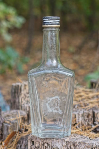 one big dirty gray glass bottle stands on a stump