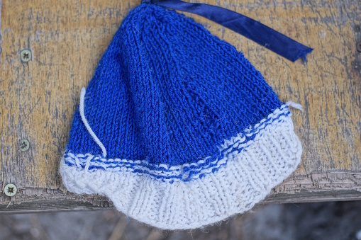 one winter blue white winter woolen knitted hat lies on a brown table