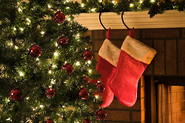 istock Christmas tree, and stockings hanging from mantel by fireplace 173574118