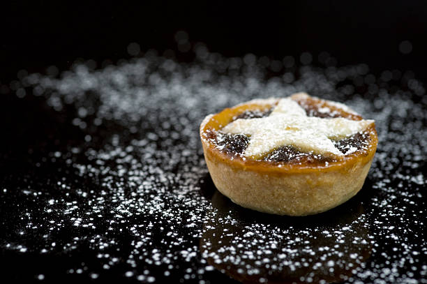 Single christmas mince pie on black background stock photo
