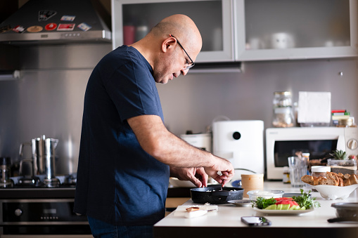 middle-aged man preparing food at home