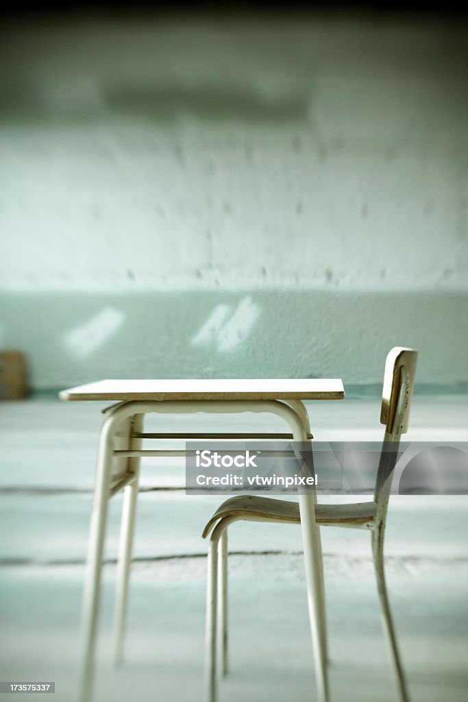 Empty school desk and chair set  Chair and desk abandonned in a school being demolished. Shot with Canon 50D / Lensbaby, short depth of field. Some visible grain. Abandoned Stock Photo