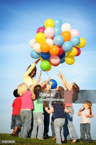 Gruppe Von Glücklich Kinder Greifen Für Ballons Stockfoto und mehr Bilder von Bunt - Farbton - Bunt - Farbton, Luftballon, In einer Reihe