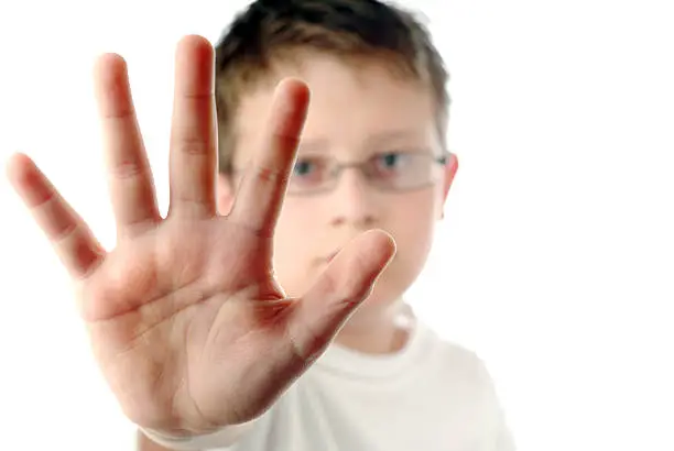 "Image of young boy with hand outstretched, warding off any unwelcome situations. Focus is on the bottom of the hand and begins to fade toward the fingers; face is completely out of focus.more portraits:"