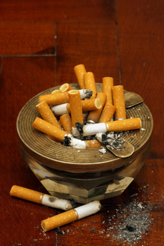 Details of cigarette butts accumulated in pedestal ashtray