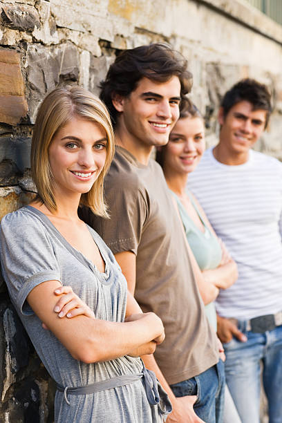 istock Smiling young boys and girls standing by wall 173578759